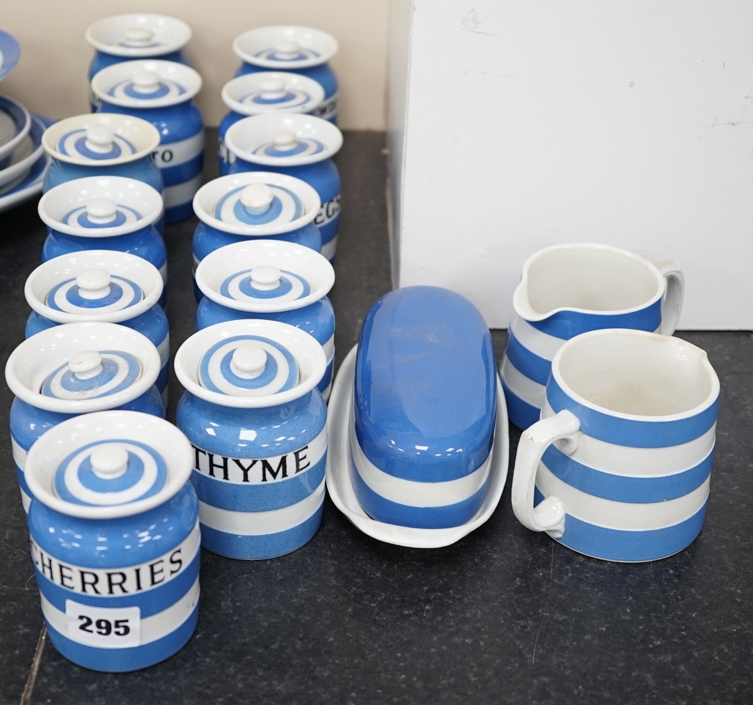 T.G.Green Cornish Kitchenware, thirteen 9cm lidded storage jars, to include Lemon Peel, Custard Powder, Nutmegs, Celery Seeds, Bisto, Parsley and Mint, together with an oval butter dish and two small jugs, mixed marks. C